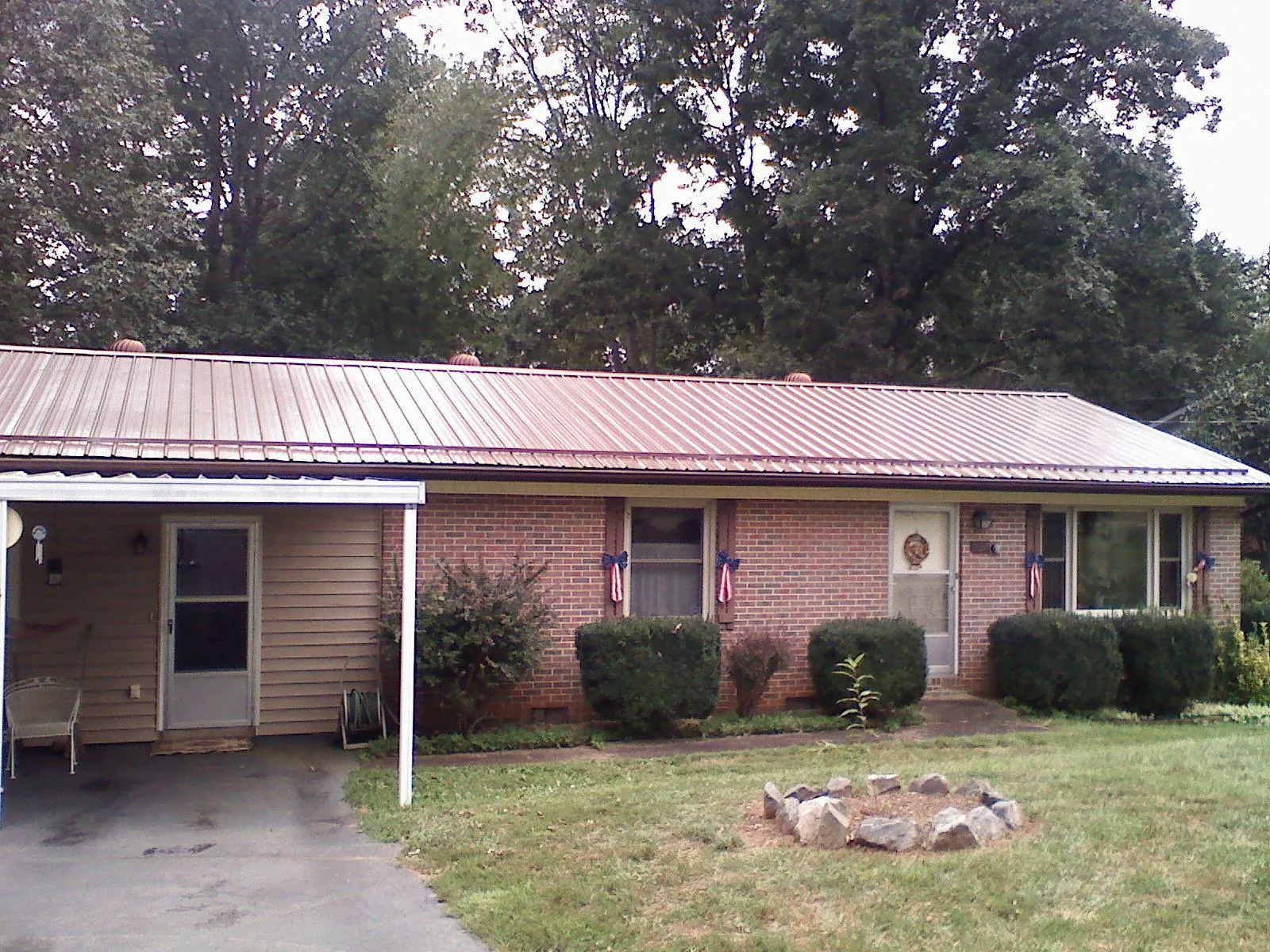 Bronze metal roof and carport on a brick ranch home — Roof Repair work by our crew in Corning